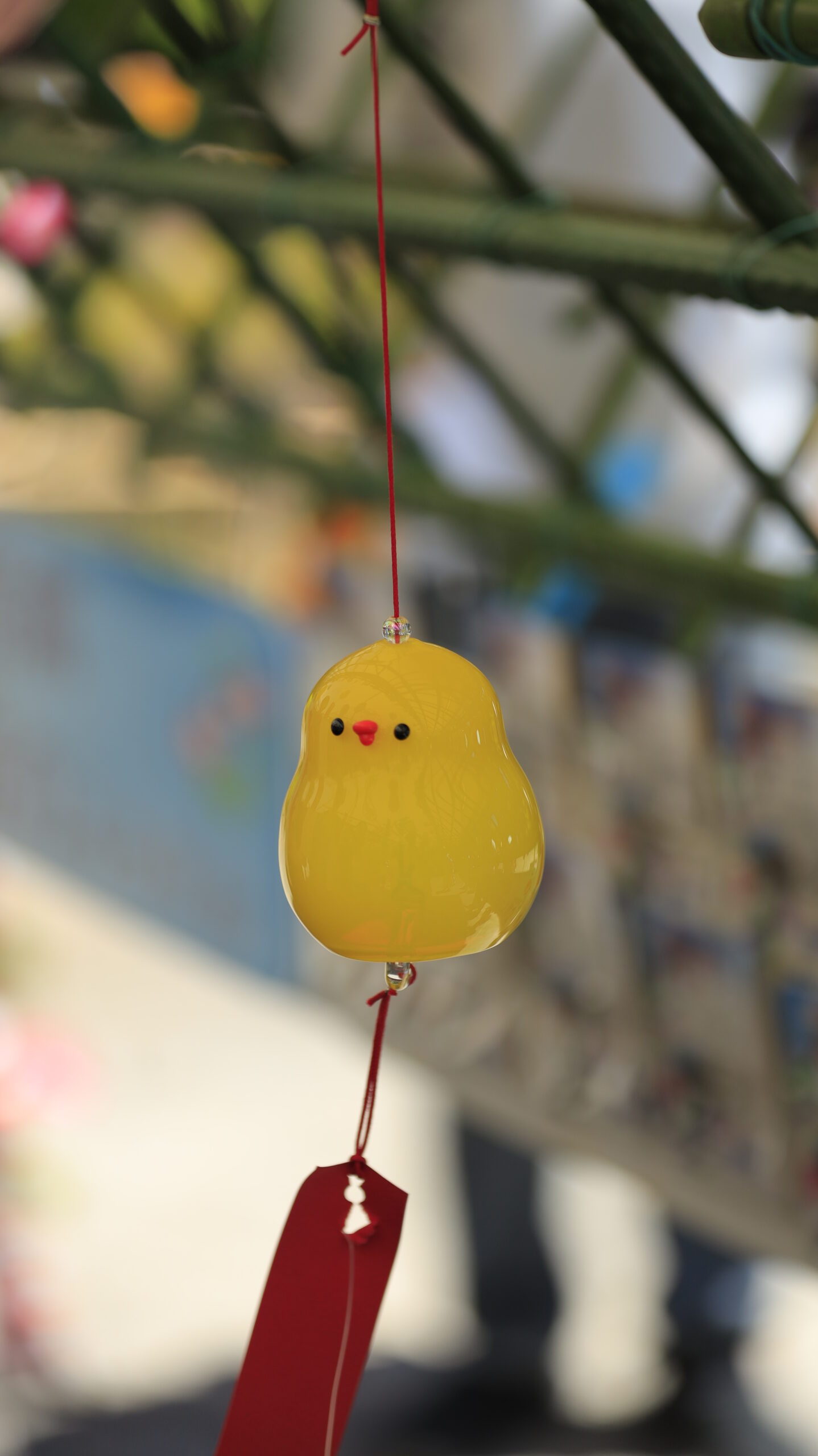 川崎大師の風鈴市で黄色いひよこの風鈴をアップで撮影し、その可愛らしさを引き出した愛情あふれる構図。